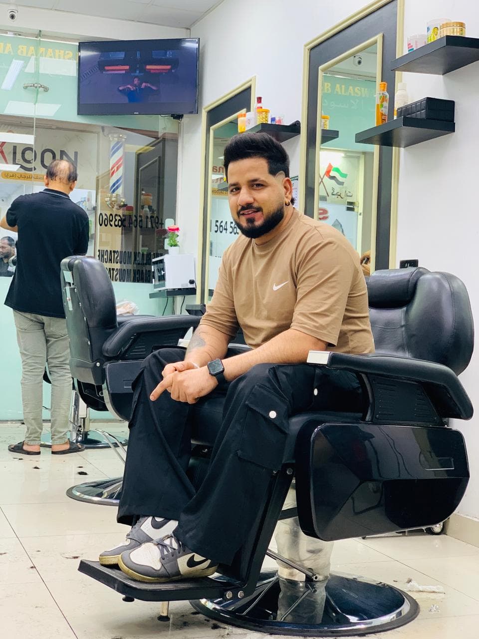 Customer seated in a barber chair inside Alshanab Al Aswad Gents Salon